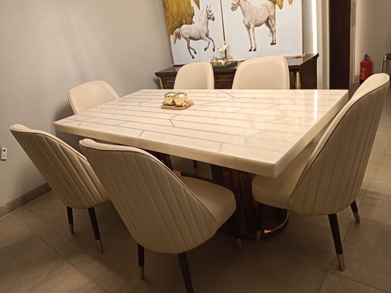 White inlay stone dining table with blush chairs inside the Little Star showroom in New Delhi