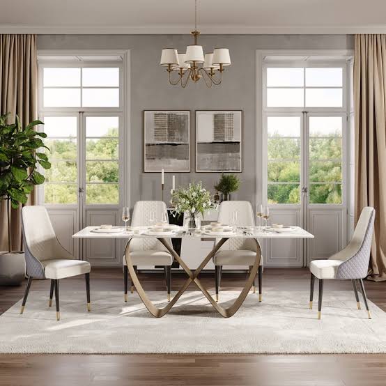White marble dining table with bronze ribbon base styled with chandelier